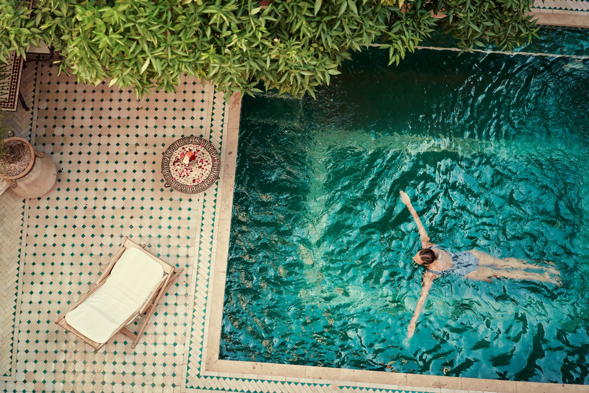 Frau schwimmt in einem stilvoll dekorierten Pool.