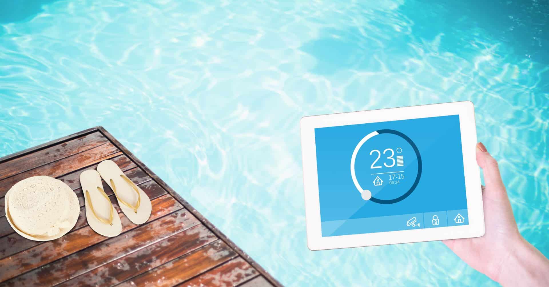 Tablet mit Anzeige der Pooltemperatur neben Flip-Flops.