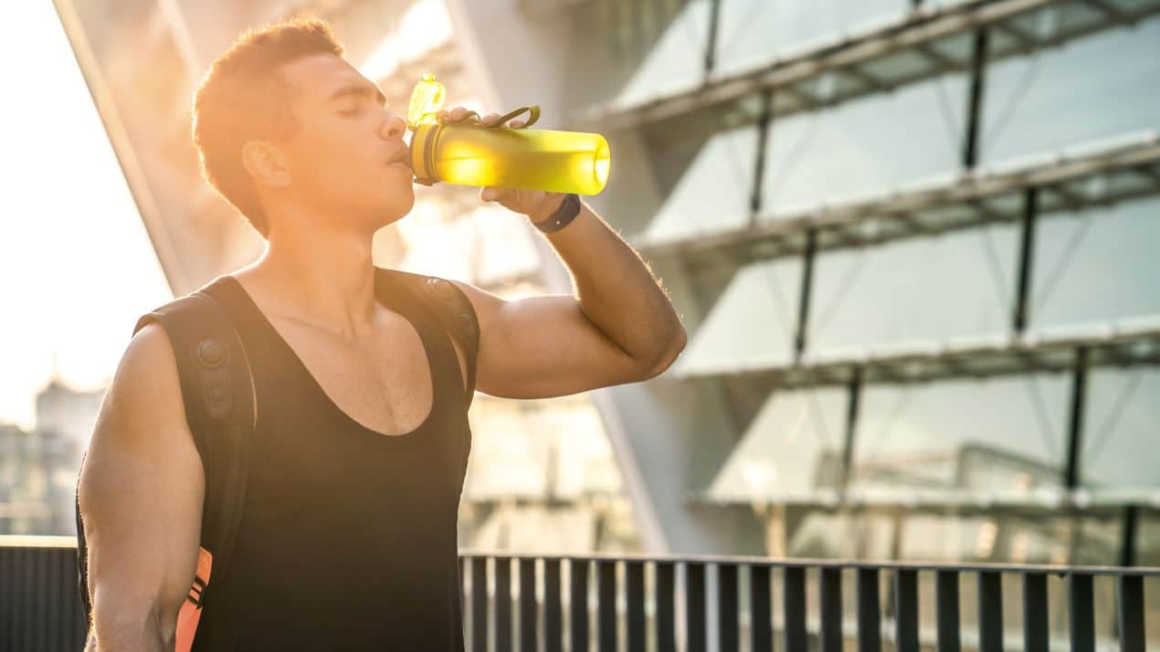 Sportler trinkt Wasser auf Tour – Flüssigkeitshaushalt und Omega-3 Algenöl als Energiequelle für lange Wanderungen.